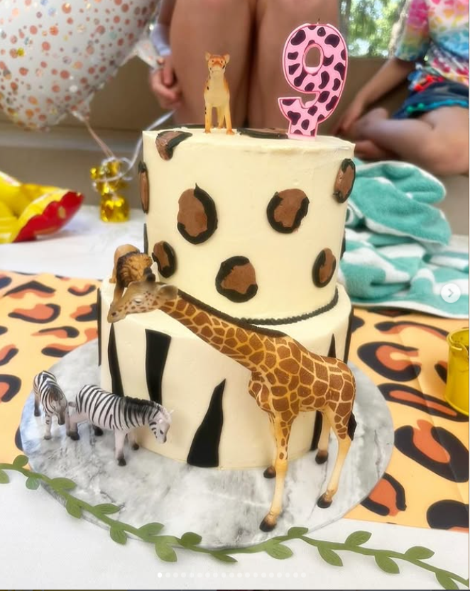 Two-tier safari themed cake with leopard print and animal figurines