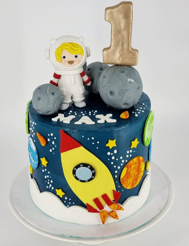 Space themed first birthday cake with rocket, planets and astronaut